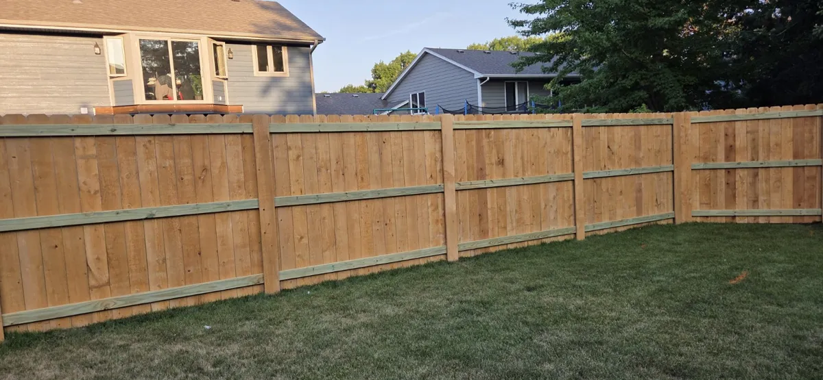 Backyard wood fence showing horizontal support rails