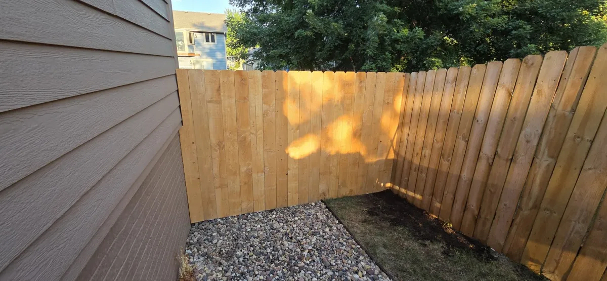 Wood fence following a corner beside a home